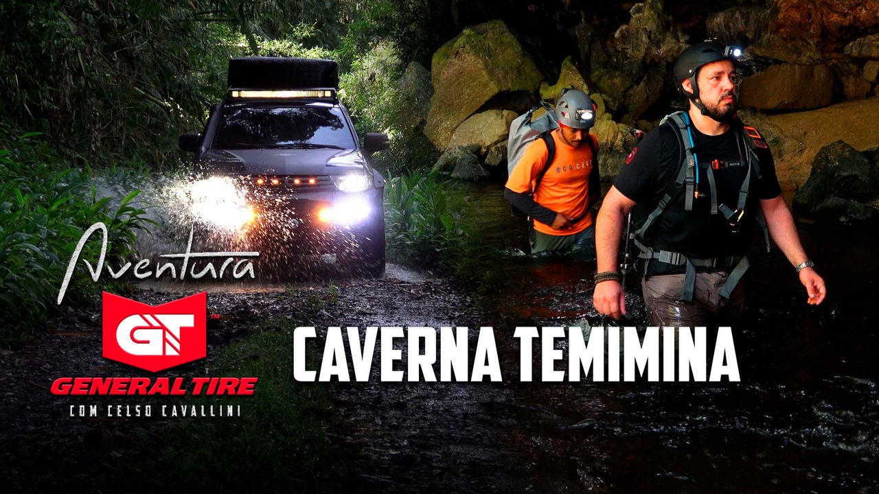 A imagem mostra Celso Cavallini junto com um guia turístico dentro da caverna temimina. Os dois estão com água até a cintura e carregam mochilas com diversos equipamentos nas costas. Estão usando capacete com uma lanterna para explorar o interior da caverna.