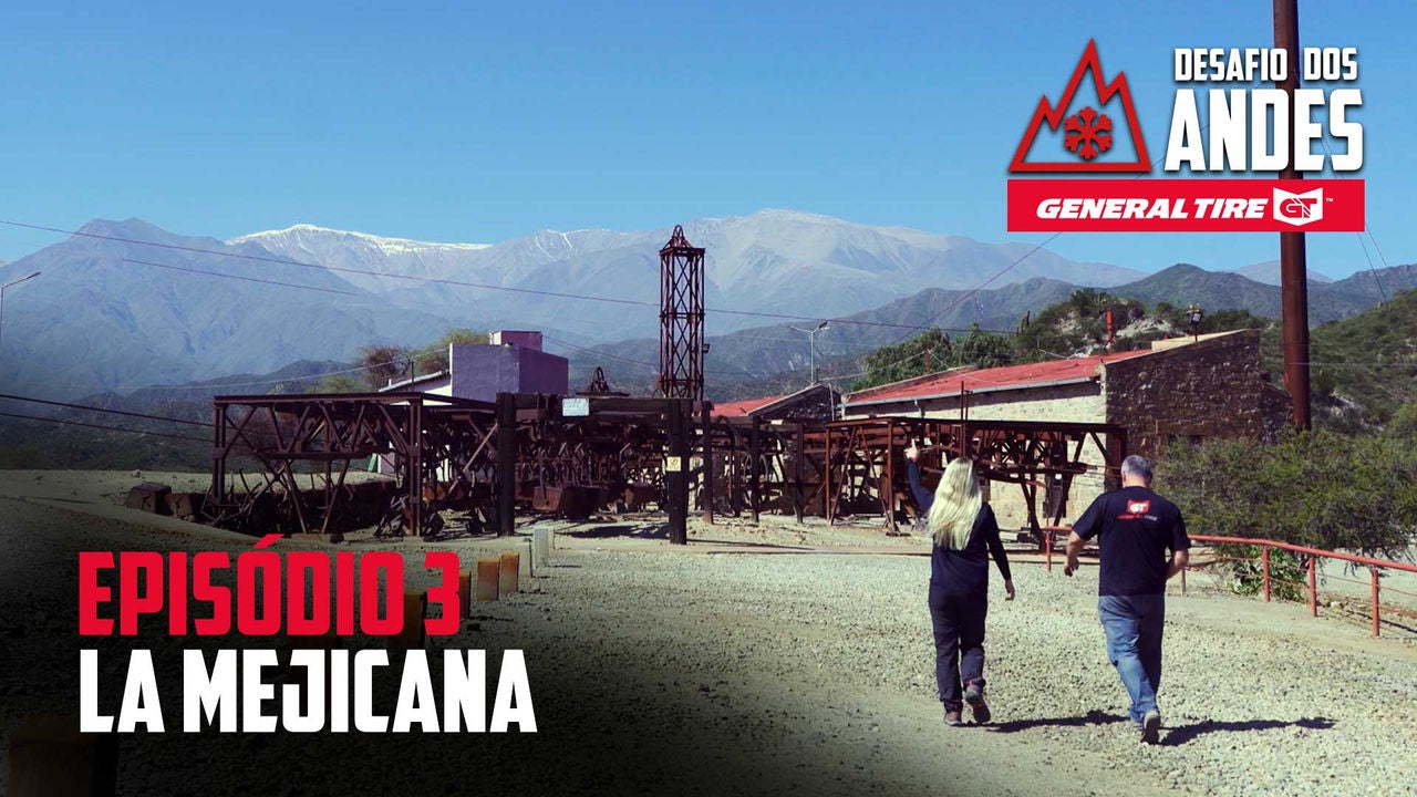 A imagem mostra duas pessoas caminhando em direção a uma antiga estrutura de mineração chamada "La Mejicana", localizada em uma região montanhosa. Ao fundo, vê-se montanhas com picos cobertos de neve sob um céu claro. No canto superior direito, há os logos “Desafio dos Andes” e “General Tire”. No canto inferior esquerdo, o texto “Episódio 3: La Mejicana” destaca o título do episódio.